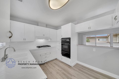 a white kitchen with white cabinets and black appliances